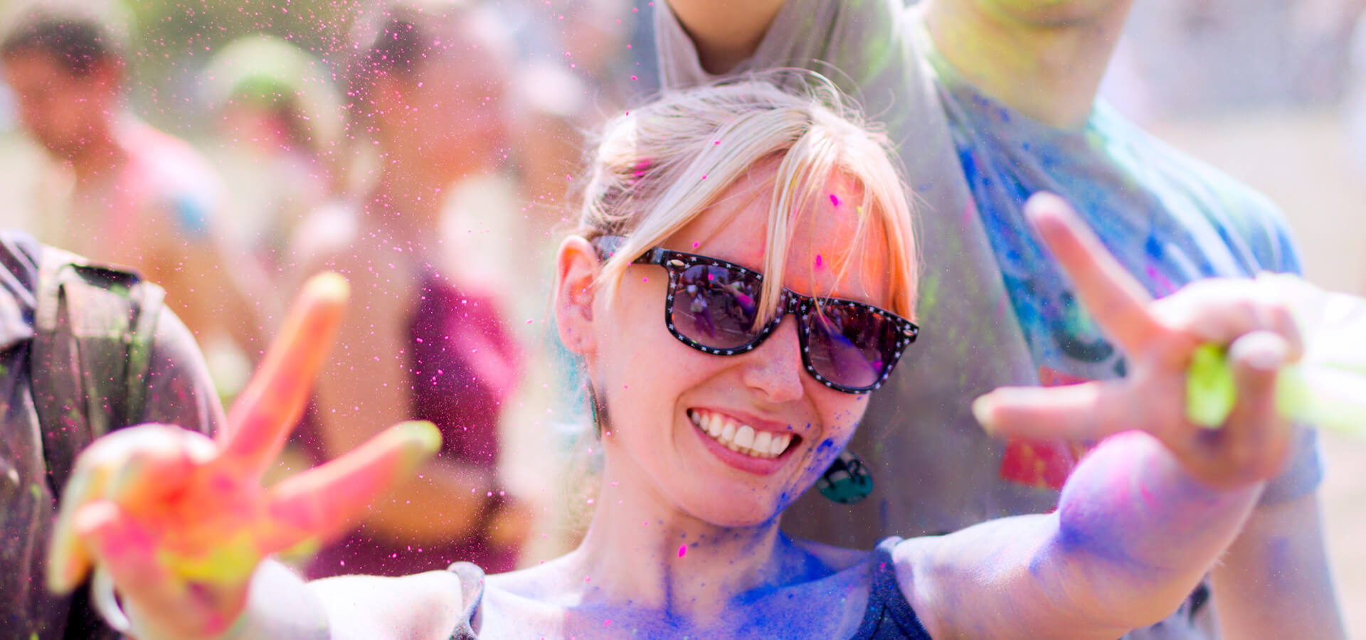 Smiling Woman in Sunglasses and Covered in Paint