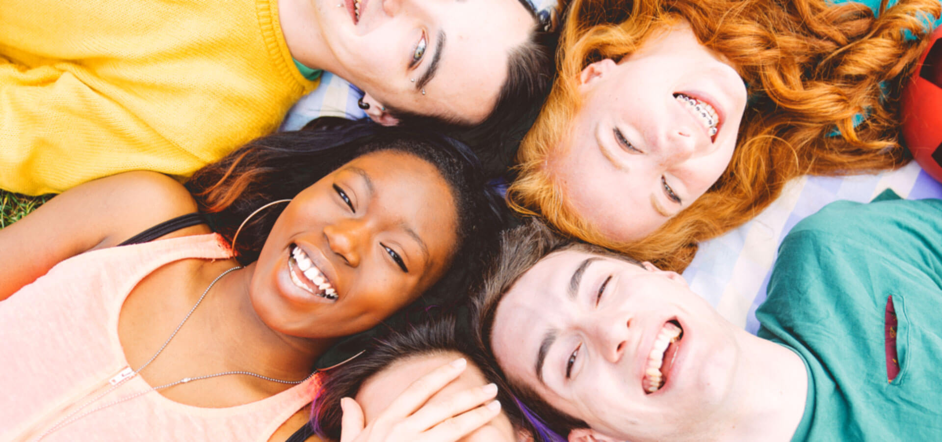 Smiling Teenagers Lying in a Circle on the Ground