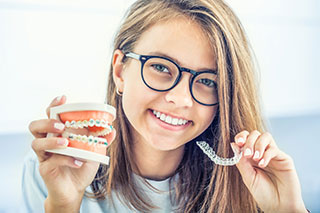 Girl holding orthodontics appliances